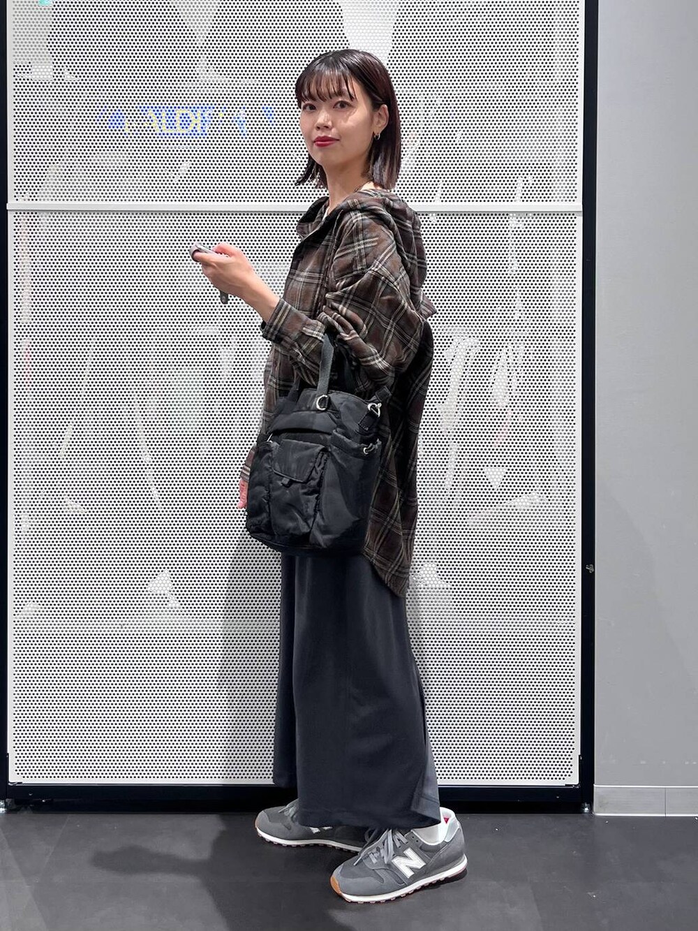 グレー系のスニーカー、グレー系のスカート、ホワイト系のTシャツ/カットソーを着用したレディースの秋コーディネートの3枚目の写真