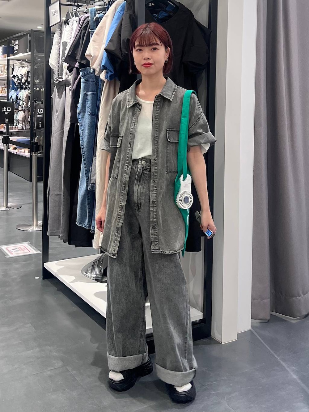 ブラック系のデニムパンツ、ブラック系のスニーカー、ブラック系のシャツ/ブラウスを着用したレディースの春コーディネートの3枚目の写真