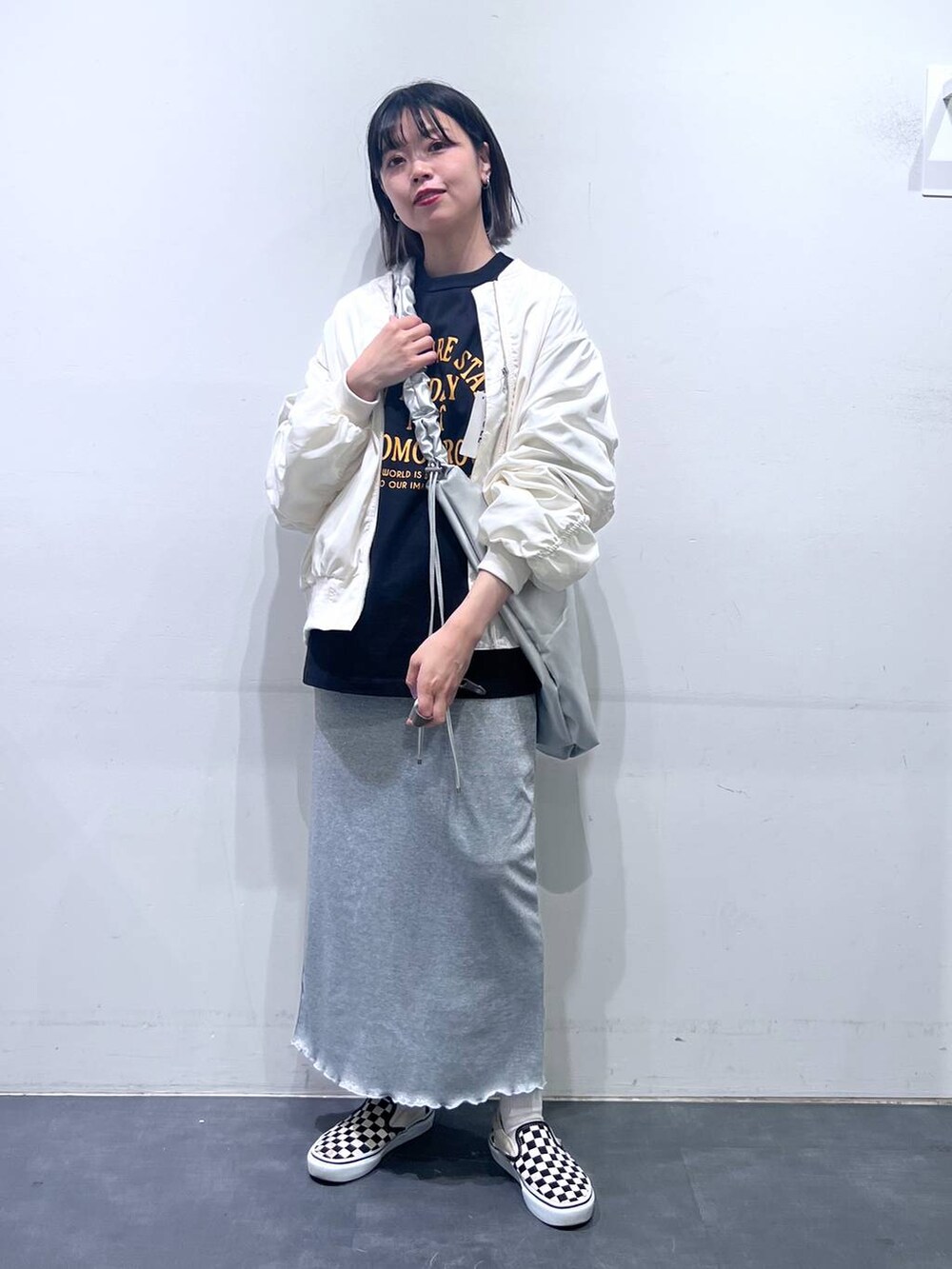 グレー系のスカート、ベージュ系のMA-1、ブラック系のTシャツ/カットソーを着用したレディースの春コーディネートの2枚目の写真