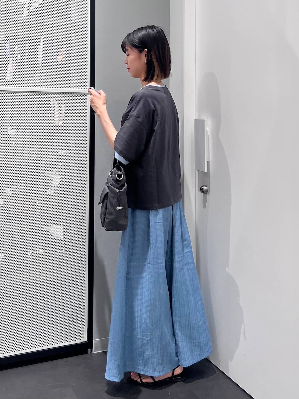 グレー系のTシャツ/カットソー、グレー系のトートバッグ、ブラック系のサンダルを着用したレディースの夏コーディネートの4枚目の写真