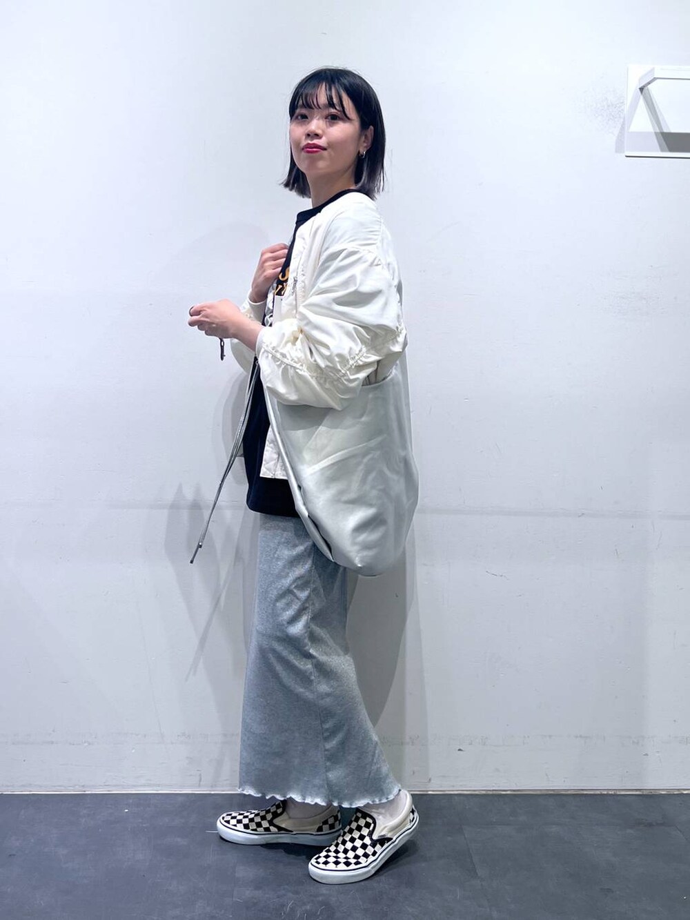 グレー系のスカート、ベージュ系のMA-1、ブラック系のTシャツ/カットソーを着用したレディースの春コーディネートの3枚目の写真