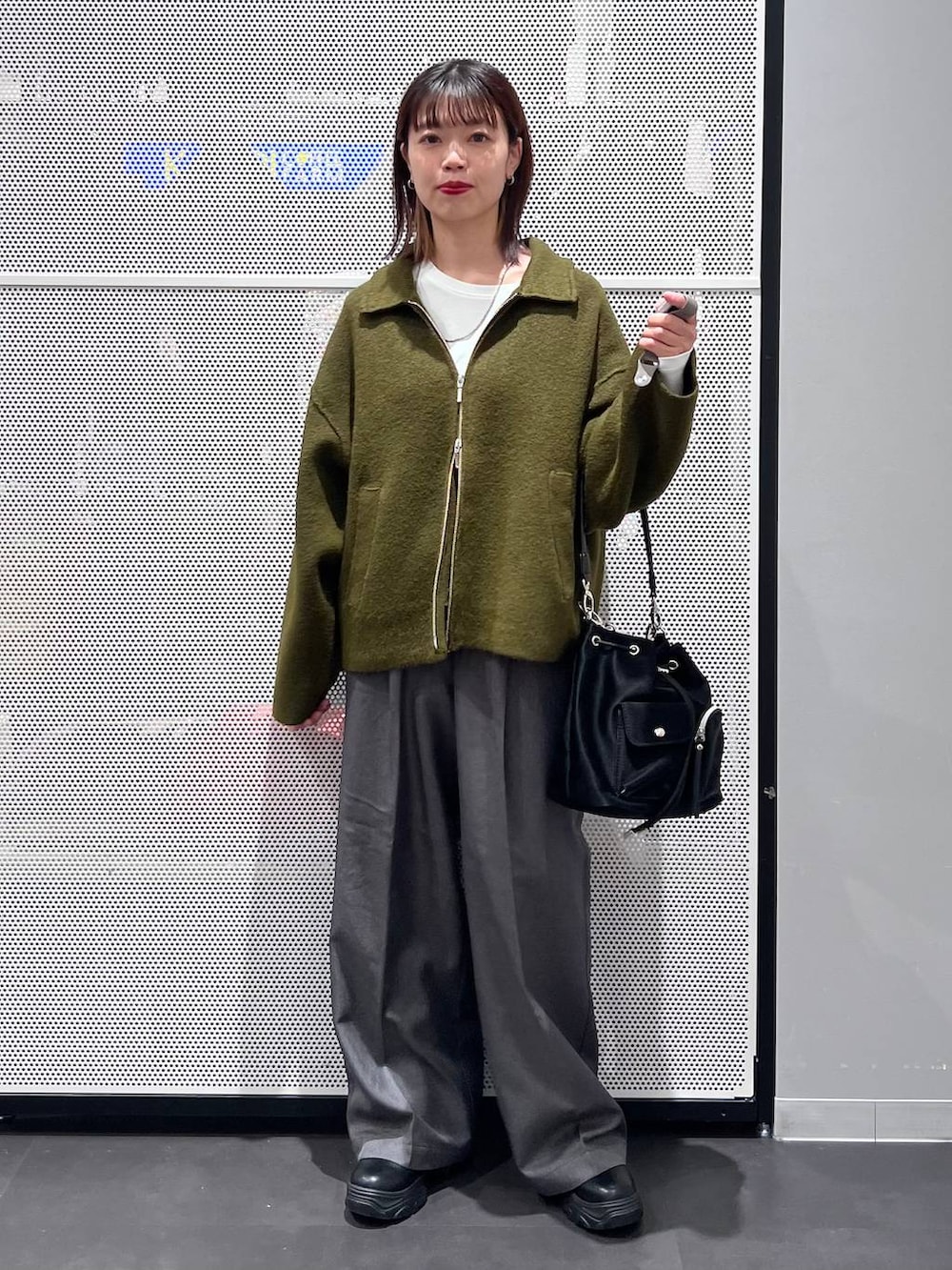 ブラック系のショルダーバッグ、ブラック系のブーツ、ホワイト系のTシャツ/カットソーを着用したレディースの秋コーディネートの2枚目の写真