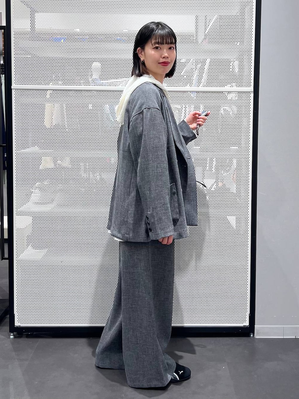 ブラック系のスニーカー、ブラック系のトートバッグ、ホワイト系のシャツ/ブラウスを着用したレディースの春コーディネートの4枚目の写真