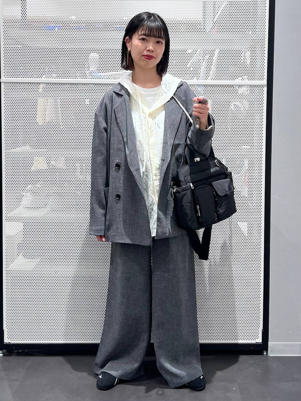 ブラック系のスニーカー、ブラック系のトートバッグ、ホワイト系のシャツ/ブラウスを着用したレディースの春コーディネートの2枚目の写真