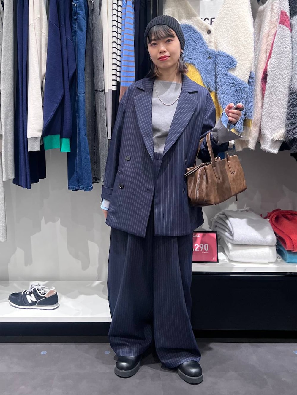 ブラウン系のボストンバッグ、ブルー系のスラックス、ブルー系のテーラードジャケットを着用したレディースの冬コーディネートの2枚目の写真