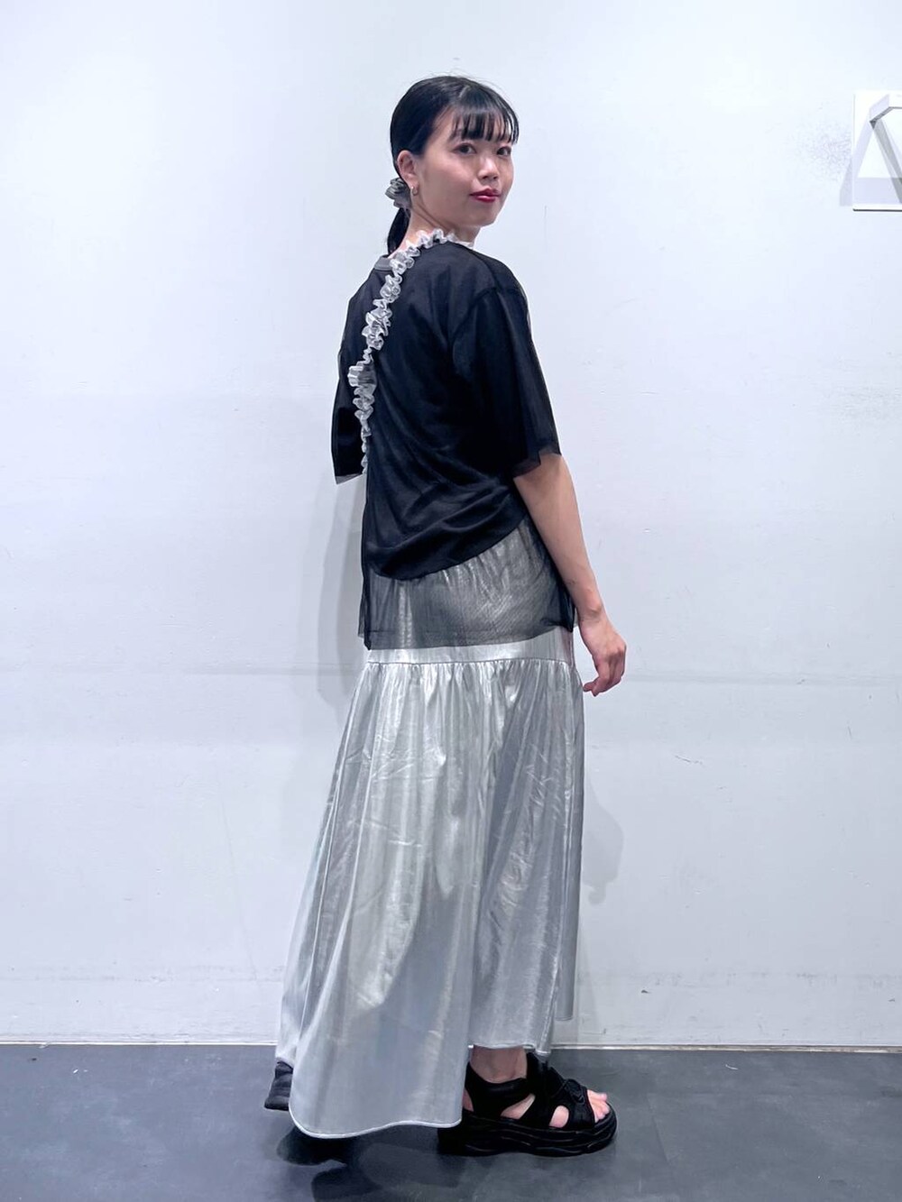 ブラック系のサンダル、シルバー系のスカート、ブラック系のTシャツ/カットソーを着用したレディースの春コーディネートの4枚目の写真