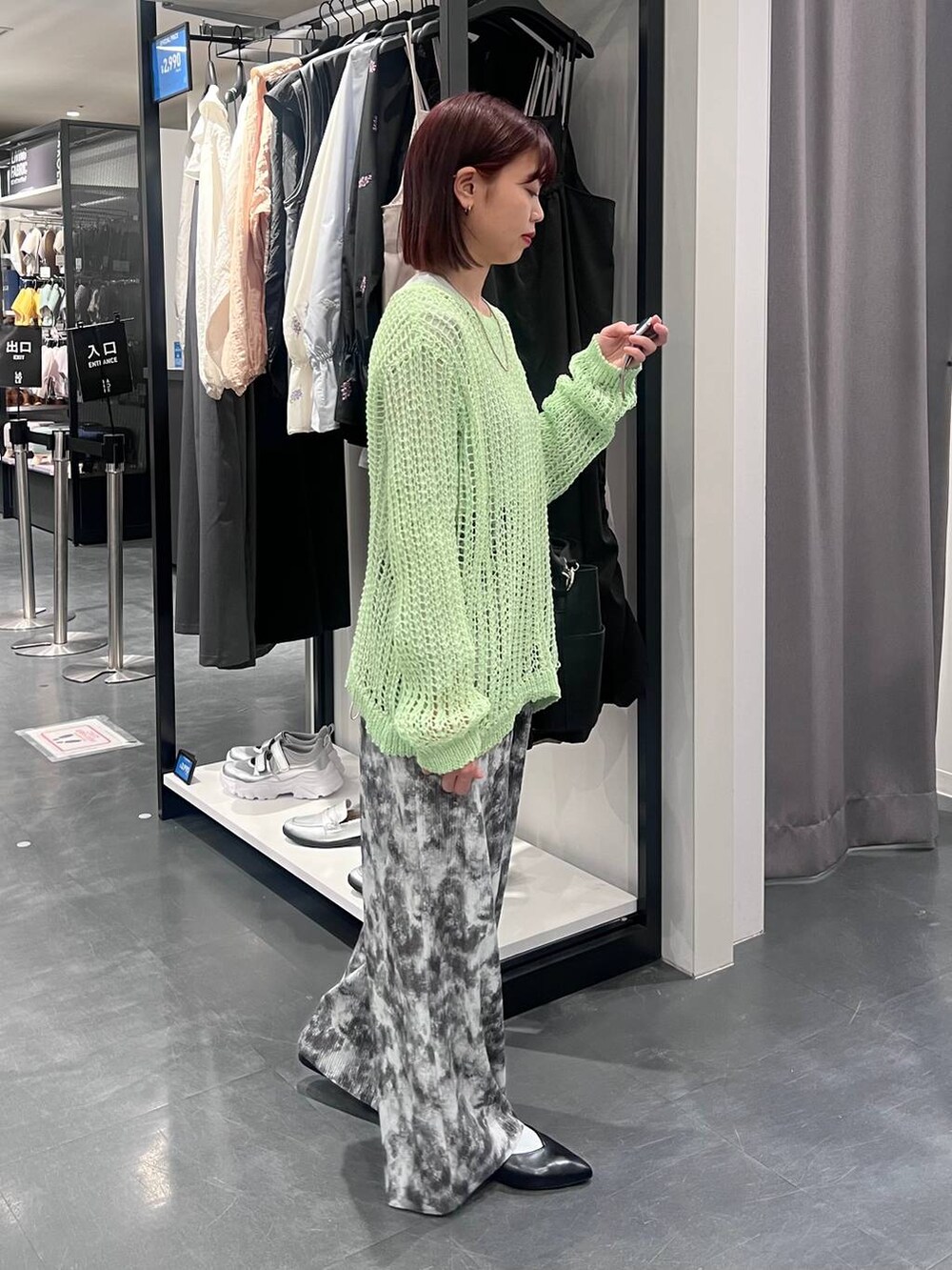 グレー系のTシャツ/カットソー、ブラック系のパンプス、グリーン系のニット/セーターを着用したレディースの春コーディネートの2枚目の写真