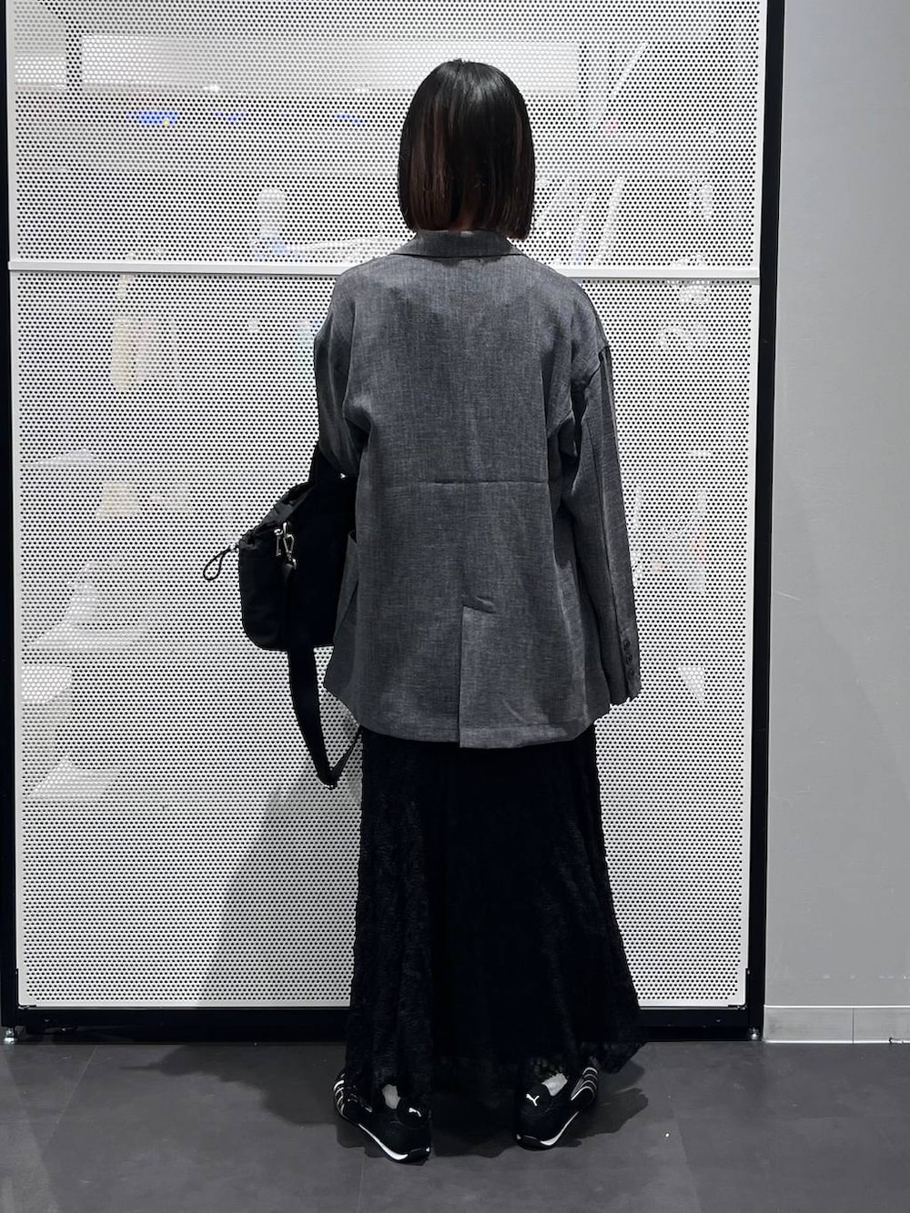 ブラック系のスニーカー、ブラック系のトートバッグ、ブラック系のスカートを着用したレディースの春コーディネートの5枚目の写真