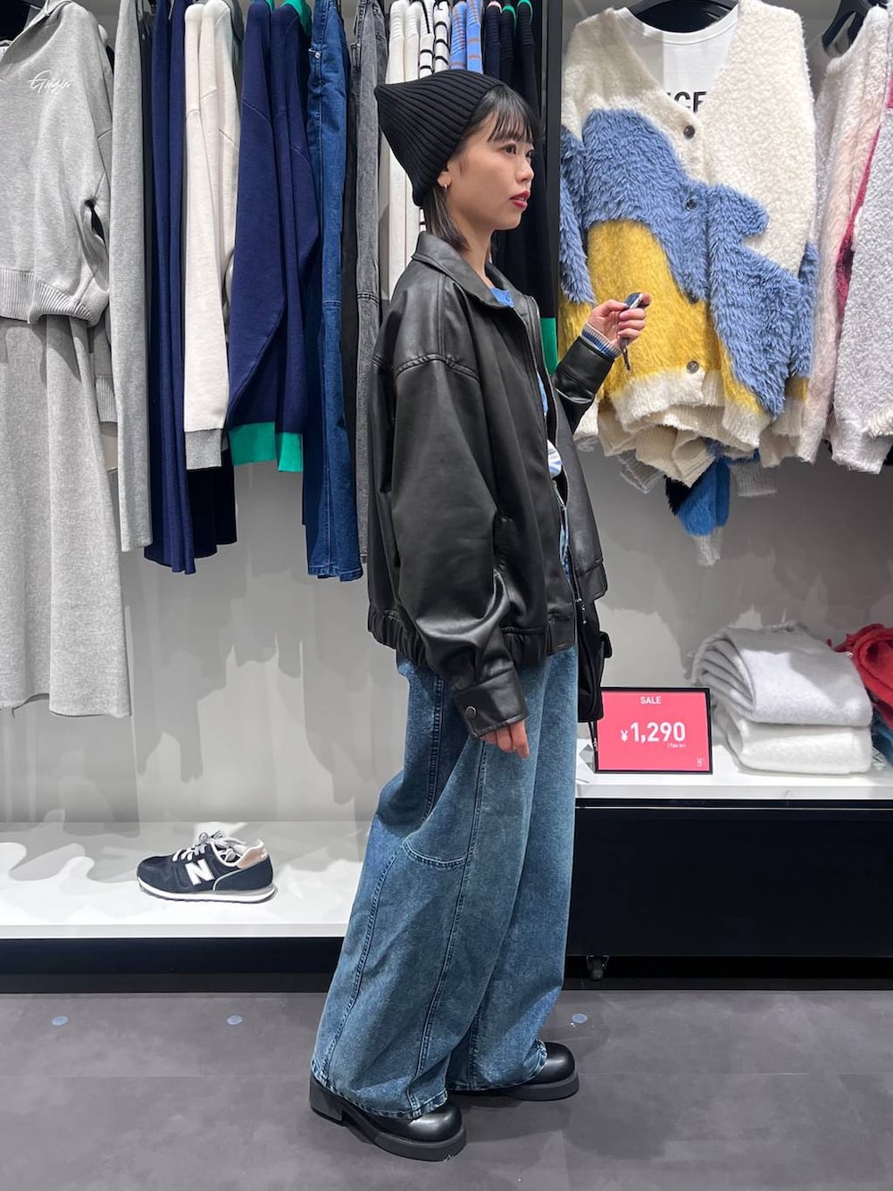 ブラック系のショルダーバッグ、ブルー系のニット/セーター、ブラック系のサンダルを着用したレディースの冬コーディネートの3枚目の写真