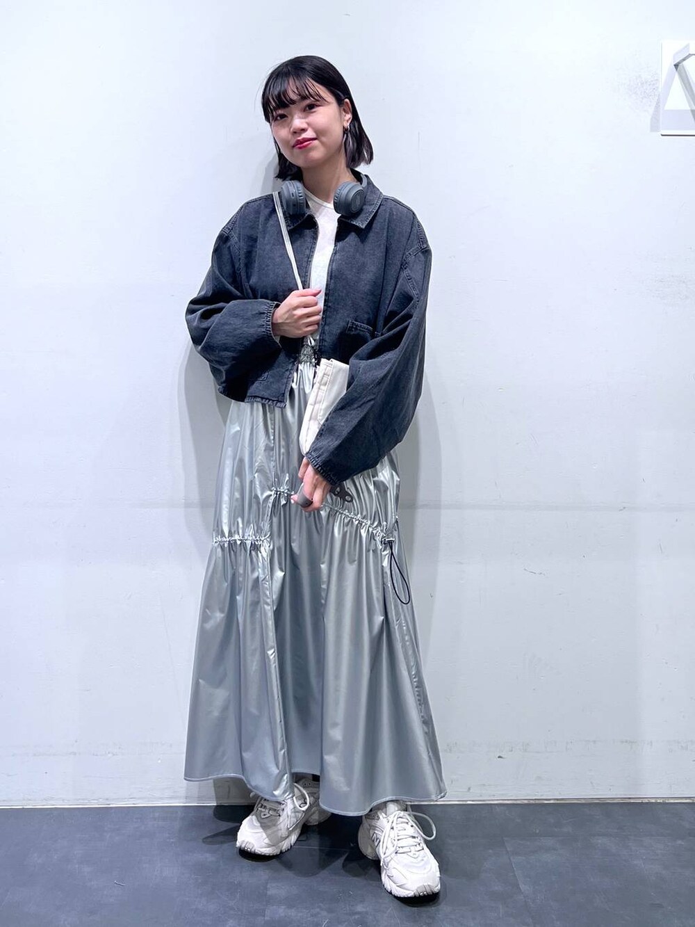 グレー系のデニムジャケット、シルバー系のスカート、ホワイト系のTシャツ/カットソーを着用したレディースの春コーディネートの2枚目の写真