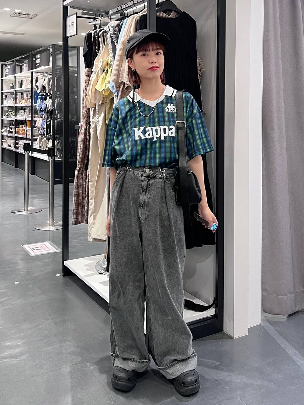 ブラック系のデニムパンツ、ブラック系のサンダル、ブラック系のショルダーバッグを着用したレディースの夏コーディネートの2枚目の写真