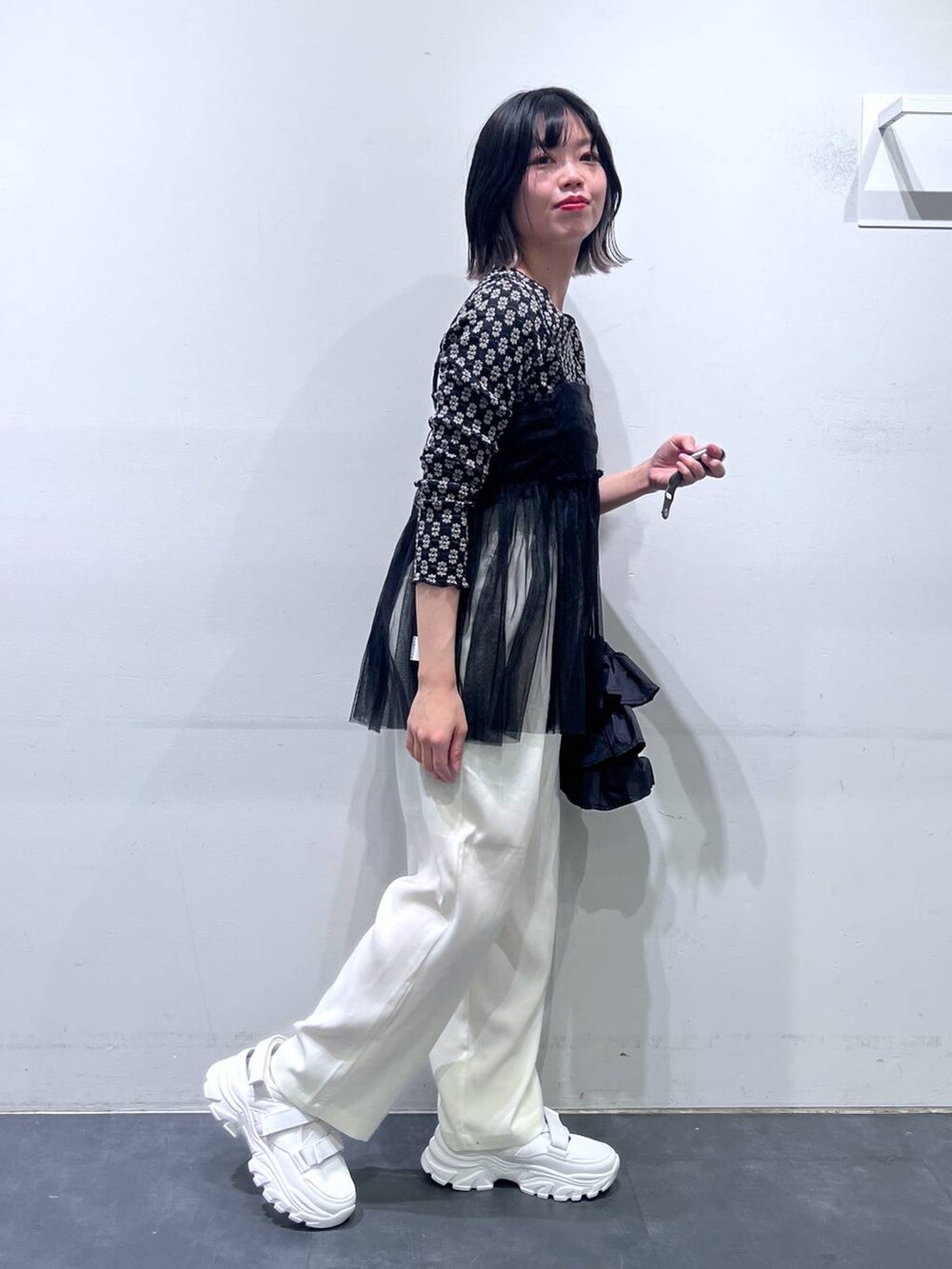 ホワイト系のスニーカー、ブラック系のTシャツ/カットソー、ホワイト系のその他パンツを着用したレディースの春コーディネートの2枚目の写真