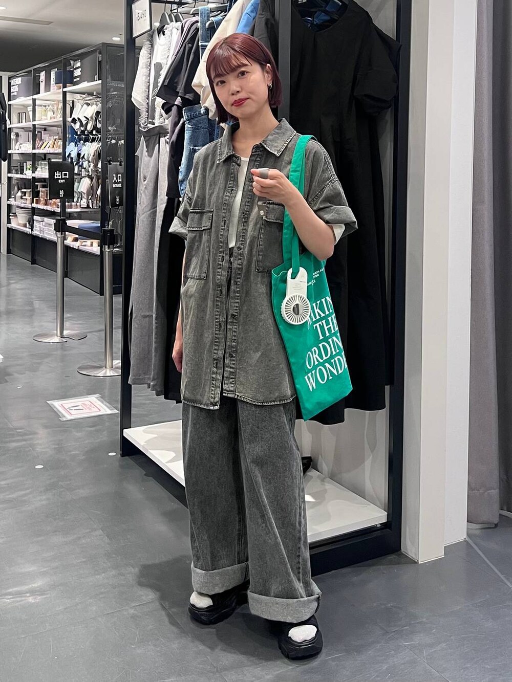 ブラック系のデニムパンツ、ブラック系のスニーカー、ブラック系のシャツ/ブラウスを着用したレディースの春コーディネートの2枚目の写真