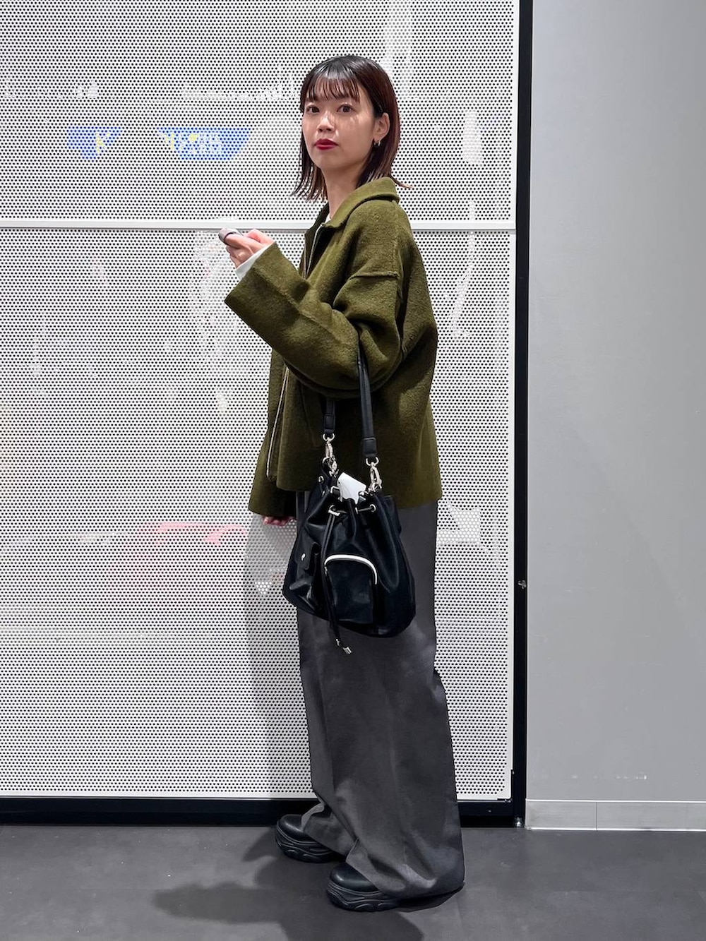 ブラック系のショルダーバッグ、ブラック系のブーツ、ホワイト系のTシャツ/カットソーを着用したレディースの秋コーディネートの3枚目の写真