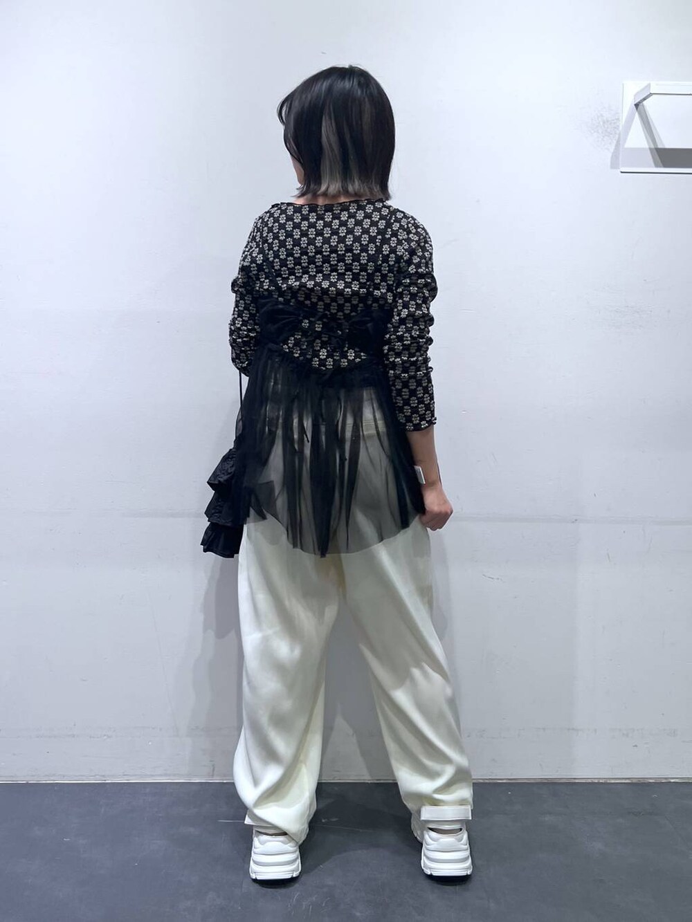 ホワイト系のスニーカー、ブラック系のTシャツ/カットソー、ホワイト系のその他パンツを着用したレディースの春コーディネートの3枚目の写真