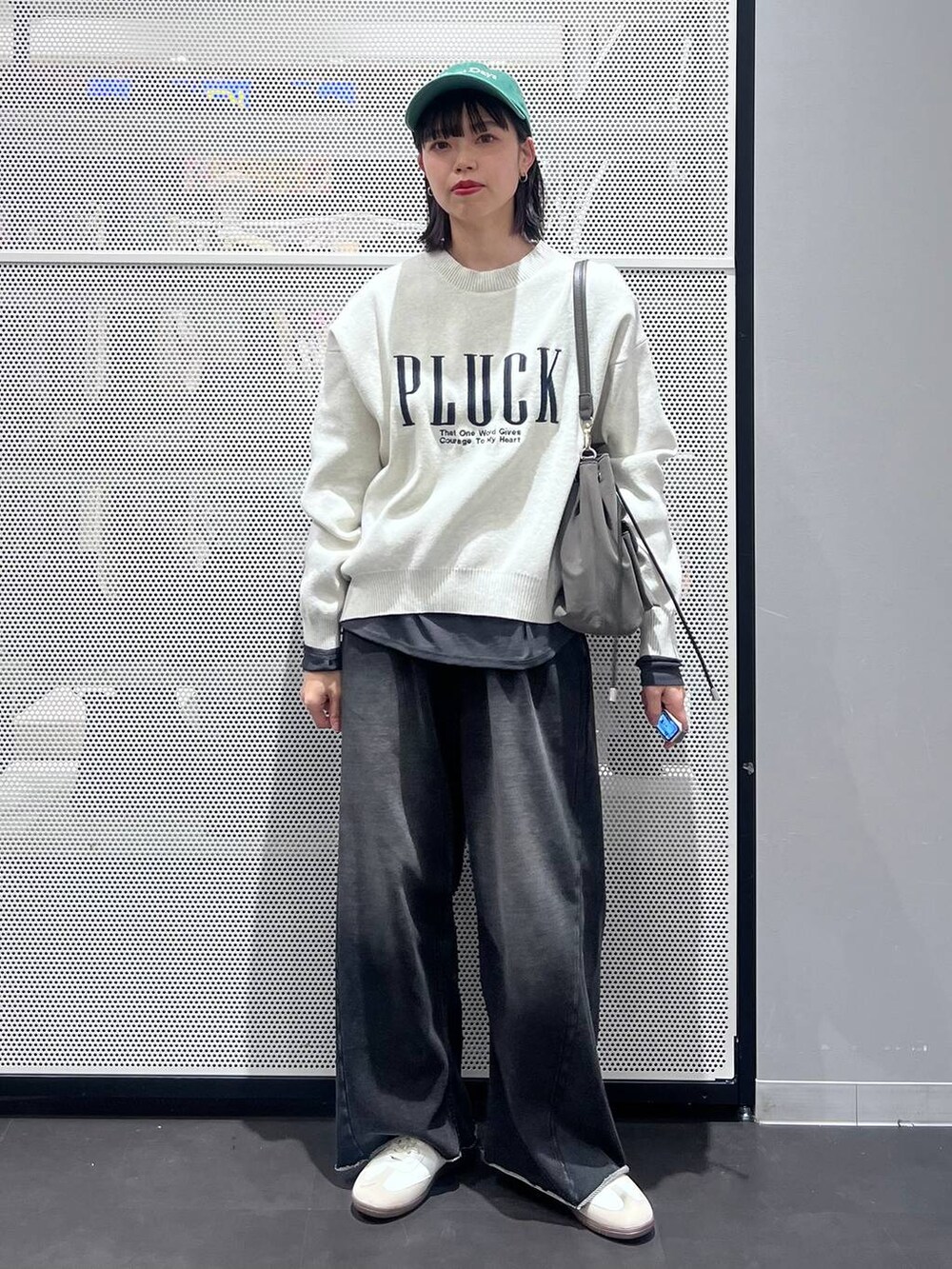 グレー系のTシャツ/カットソー、ホワイト系のスニーカー、イエロー系のニット/セーターを着用したレディースの冬コーディネートの2枚目の写真