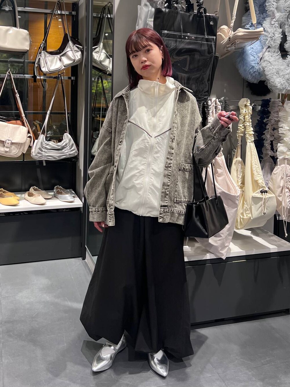 ブラック系のトートバッグ、シルバー系のパンプス、ブラック系のデニムジャケットを着用したレディースの春コーディネートの2枚目の写真