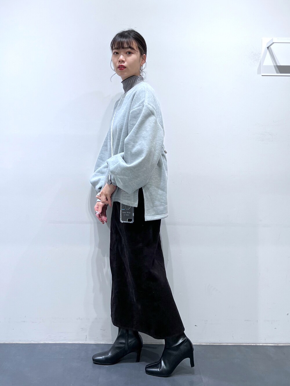 ブラック系のブーツ、ブラウン系のスカート、グレー系のスウェットを着用したレディースの冬コーディネートの2枚目の写真