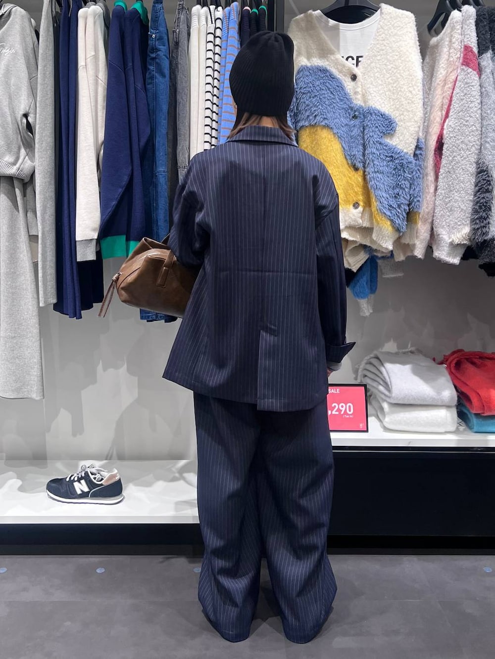 ブラウン系のボストンバッグ、ブルー系のスラックス、ブルー系のテーラードジャケットを着用したレディースの冬コーディネートの5枚目の写真