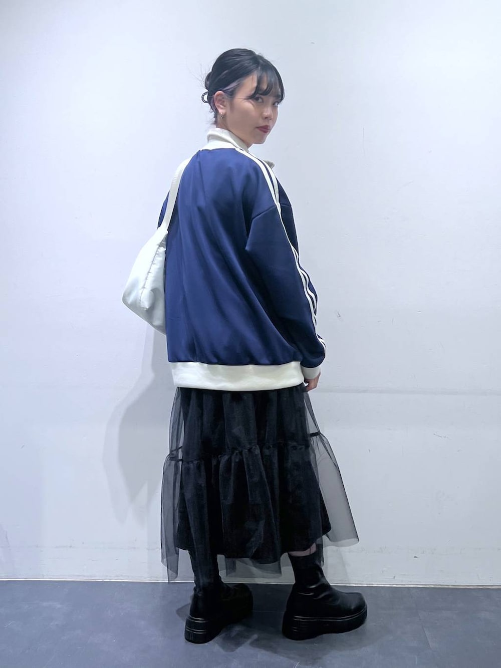 ブラック系のブーツ、ホワイト系のショルダーバッグ、ブルー系のスウェットを着用したレディースの冬コーディネートの3枚目の写真