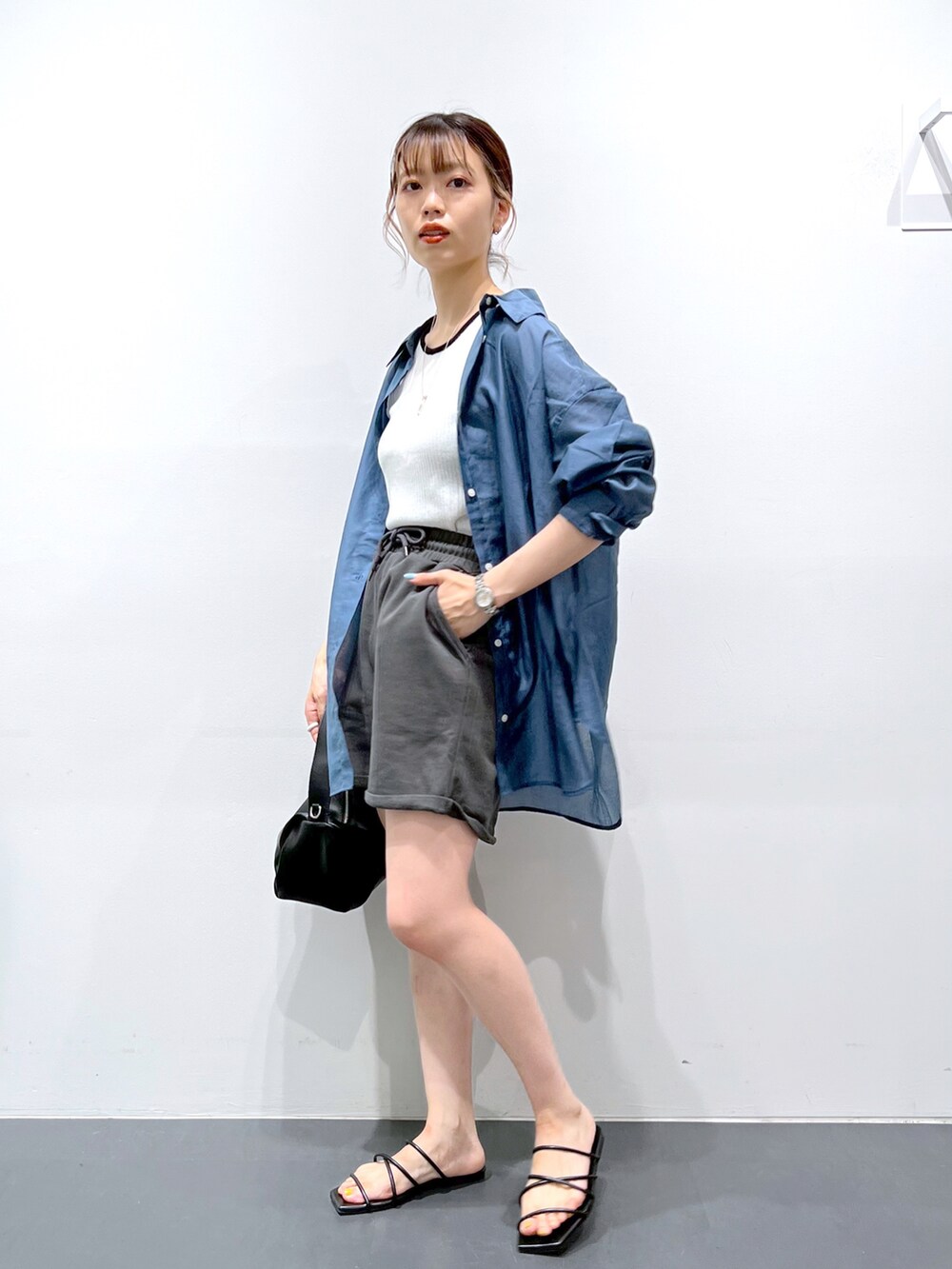 ブラック系のサンダル、ブラック系のショルダーバッグ、グレー系のスウェットパンツを着用したレディースの夏コーディネートの2枚目の写真