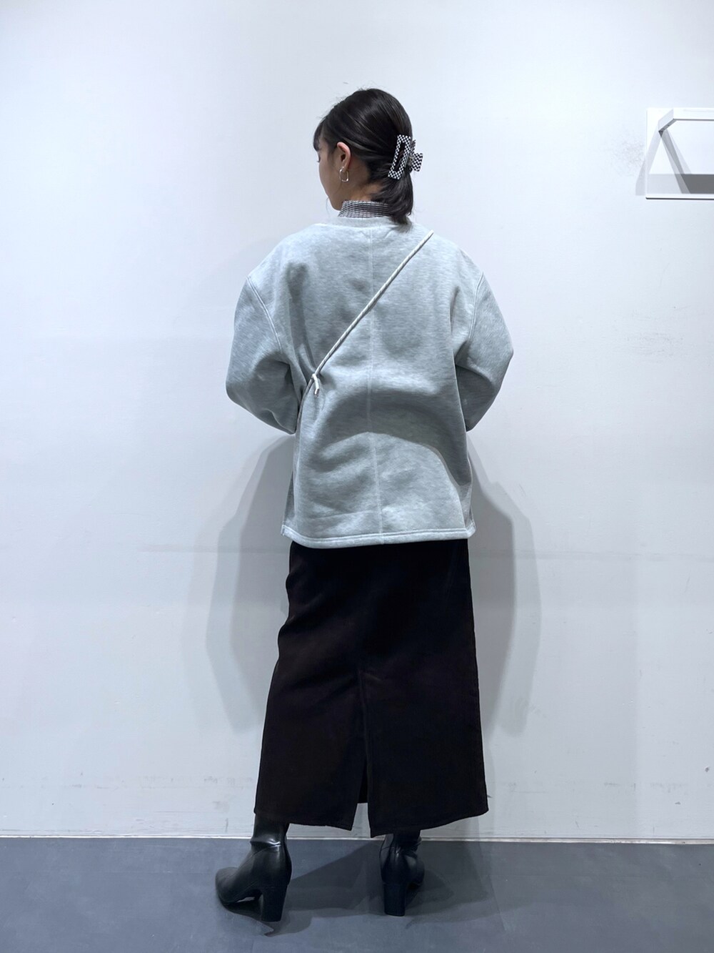 ブラック系のブーツ、ブラウン系のスカート、グレー系のスウェットを着用したレディースの冬コーディネートの3枚目の写真