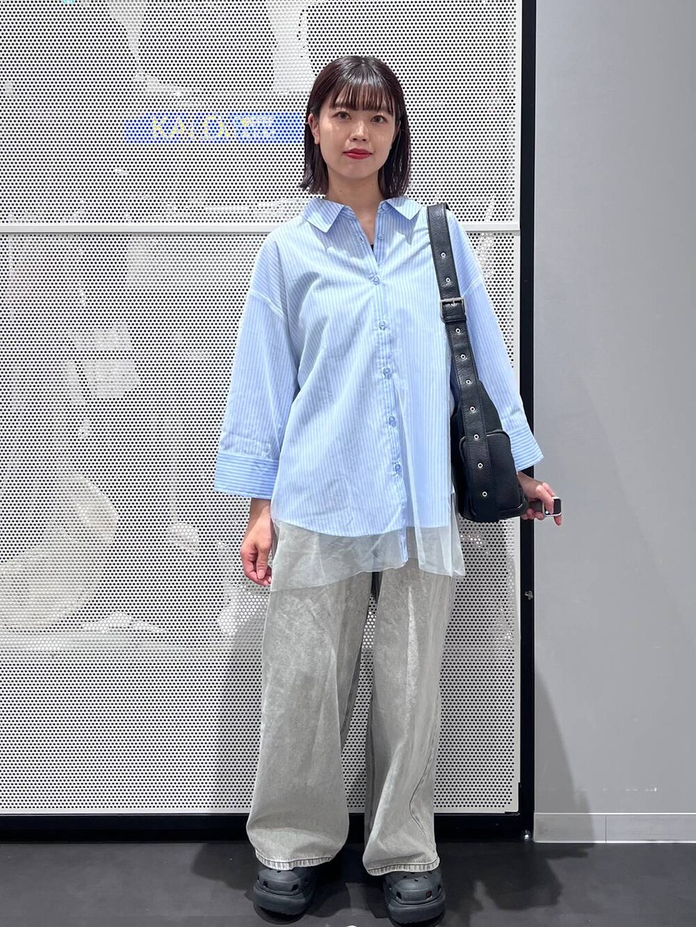 ブラック系のサンダル、ブラック系のショルダーバッグ、ブルー系のシャツ/ブラウスを着用したレディースの秋コーディネートの2枚目の写真