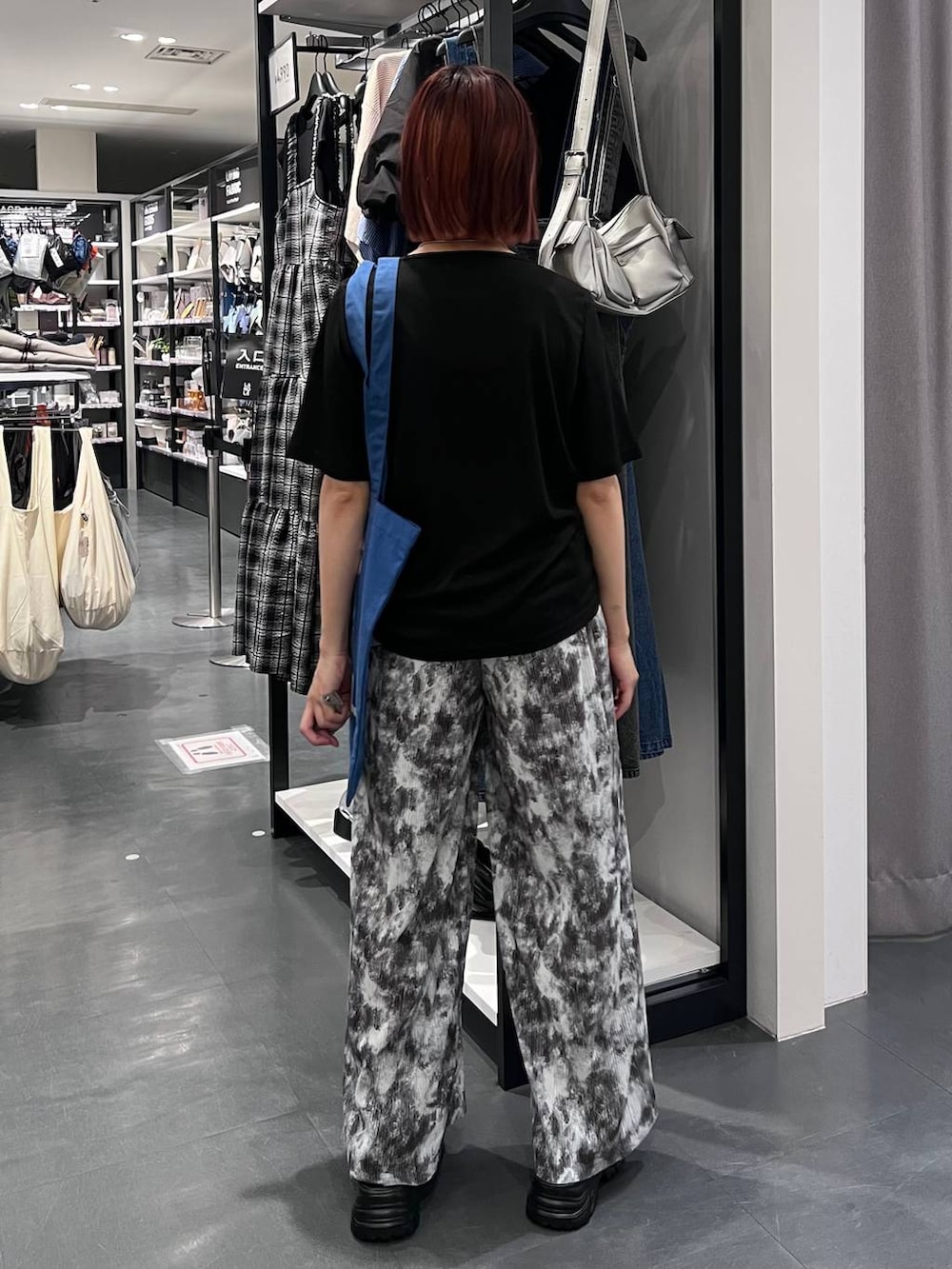 ブラック系のスニーカー、ブラック系のTシャツ/カットソー、ブルー系のトートバッグを着用したレディースの夏コーディネートの5枚目の写真