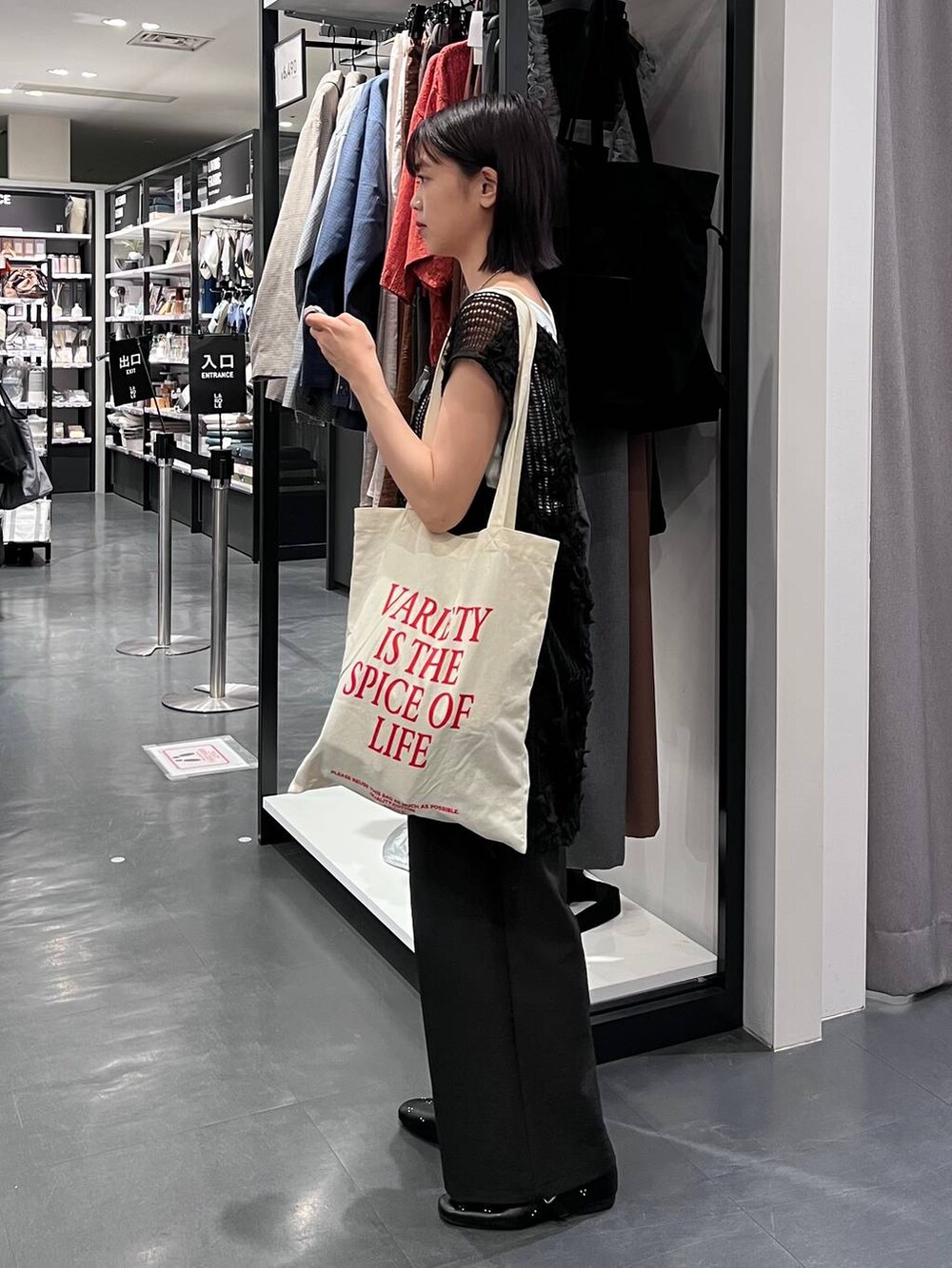 ブラック系のその他パンツ、ホワイト系のタンクトップ、ホワイト系のトートバッグを着用したレディースの秋コーディネートの3枚目の写真