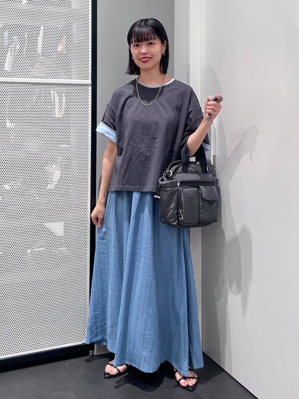 グレー系のTシャツ/カットソー、グレー系のトートバッグ、ブラック系のサンダルを着用したレディースの夏コーディネートの2枚目の写真