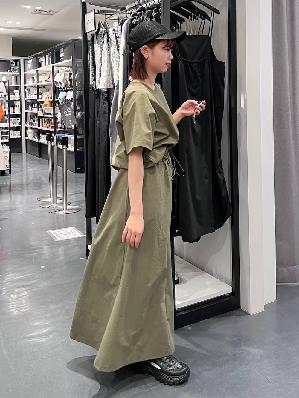 ブラック系のトートバッグ、ブラック系のスニーカー、グリーン系のTシャツ/カットソーを着用したレディースの春コーディネートの4枚目の写真