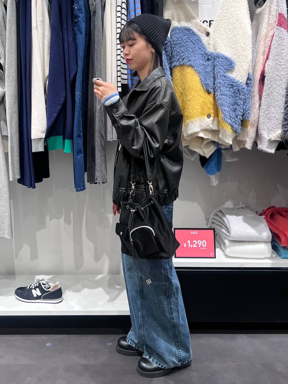 ブラック系のショルダーバッグ、ブルー系のニット/セーター、ブラック系のサンダルを着用したレディースの冬コーディネートの4枚目の写真