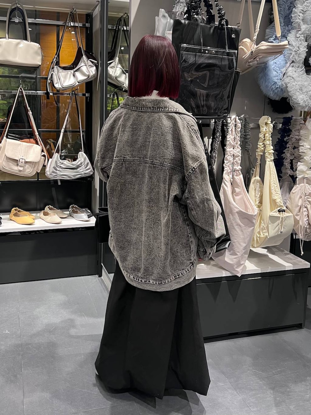 ブラック系のトートバッグ、シルバー系のパンプス、ブラック系のデニムジャケットを着用したレディースの春コーディネートの5枚目の写真
