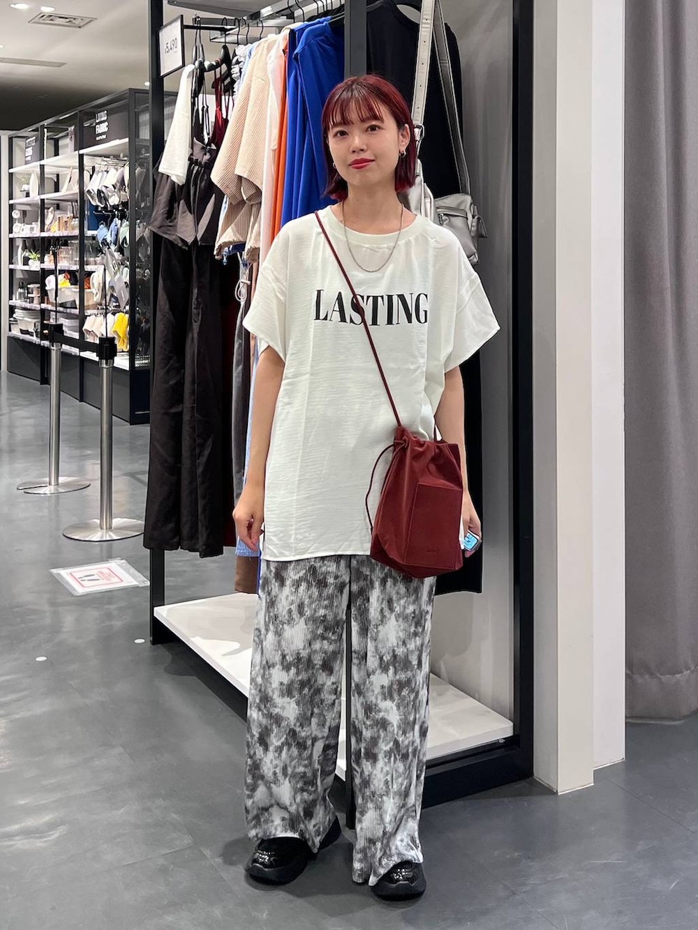 グレー系のその他パンツ、ホワイト系のTシャツ/カットソー、ブラック系のローファーを着用したレディースの夏コーディネートの2枚目の写真