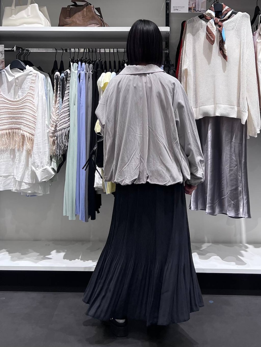 ブラック系のボストンバッグ、ブラック系のサンダル、グレー系のブルゾンを着用したレディースの春コーディネートの5枚目の写真