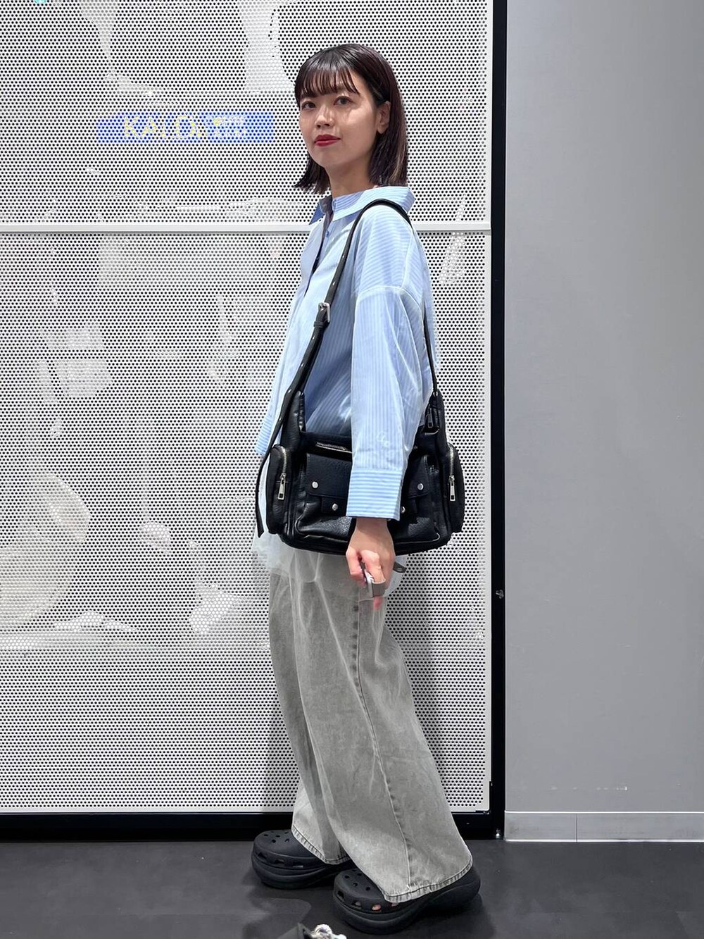 ブラック系のサンダル、ブラック系のショルダーバッグ、ブルー系のシャツ/ブラウスを着用したレディースの秋コーディネートの3枚目の写真