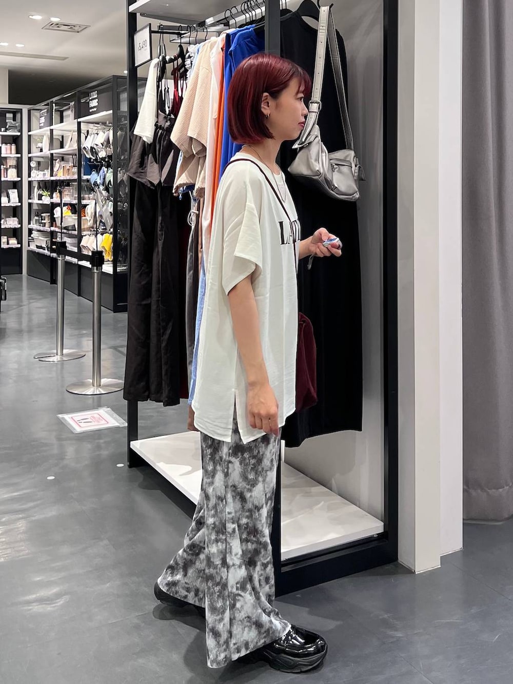 グレー系のその他パンツ、ホワイト系のTシャツ/カットソー、ブラック系のローファーを着用したレディースの夏コーディネートの4枚目の写真