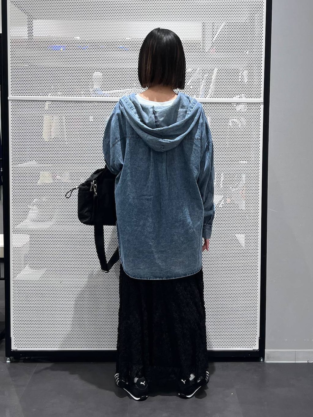 ブラック系のスニーカー、ブラック系のトートバッグ、ブラック系のスカートを着用したレディースの春コーディネートの4枚目の写真