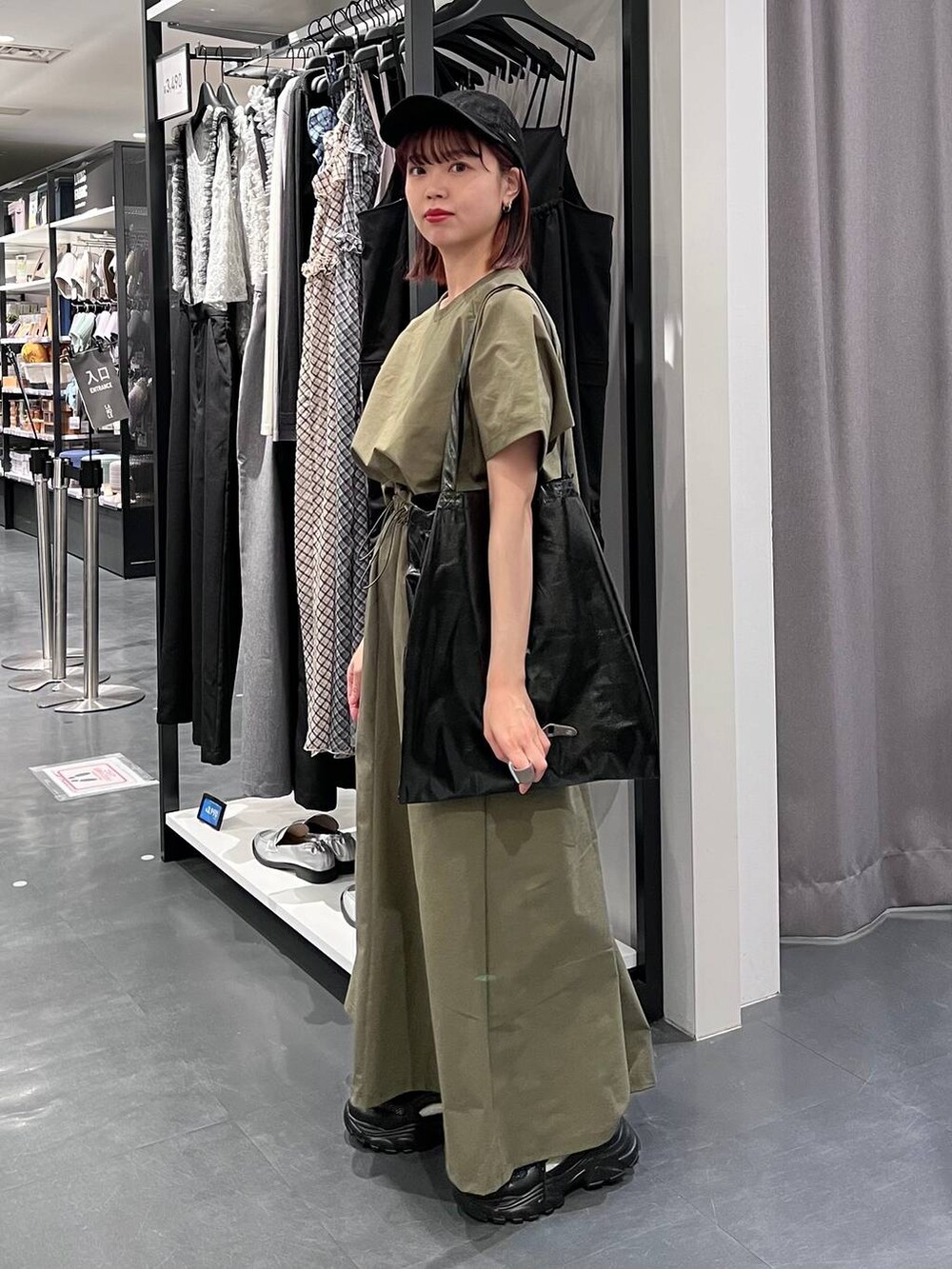 ブラック系のトートバッグ、ブラック系のスニーカー、グリーン系のTシャツ/カットソーを着用したレディースの春コーディネートの3枚目の写真