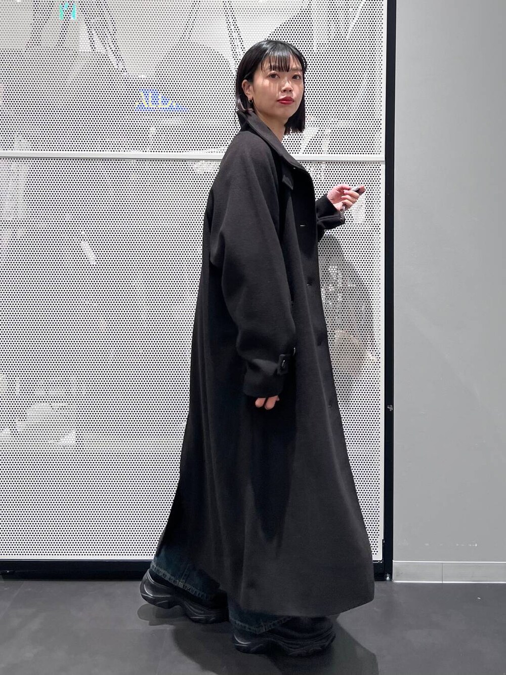 ブルー系のデニムパンツ、ブラック系のその他アウター、ブラウン系のショルダーバッグを着用したレディースの冬コーディネートの4枚目の写真