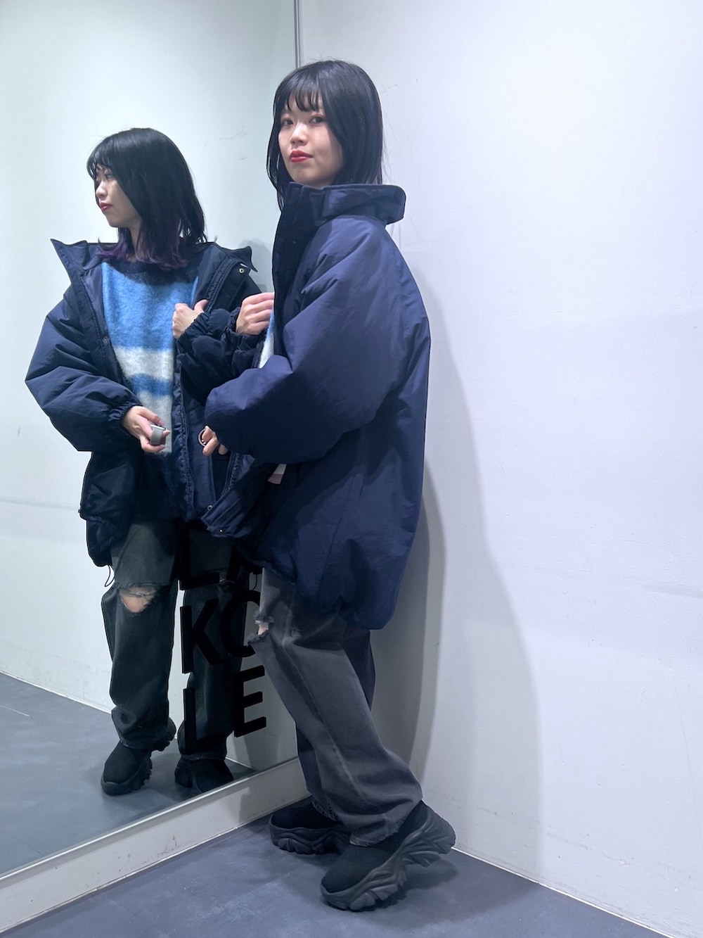 ブルー系のニット/セーター、ブルー系のナイロンジャケット、グレー系のデニムパンツを着用したレディースの冬コーディネートの3枚目の写真