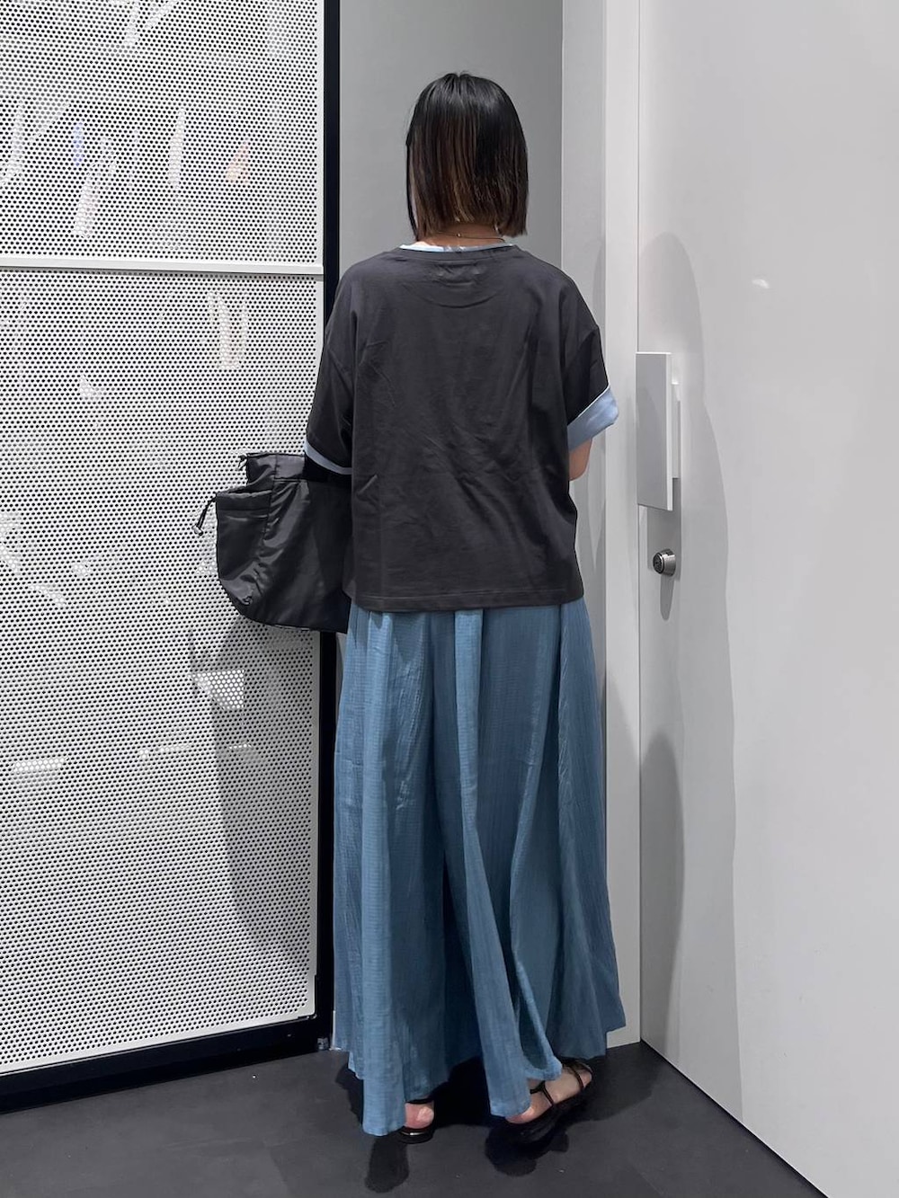 グレー系のTシャツ/カットソー、グレー系のトートバッグ、ブラック系のサンダルを着用したレディースの夏コーディネートの5枚目の写真