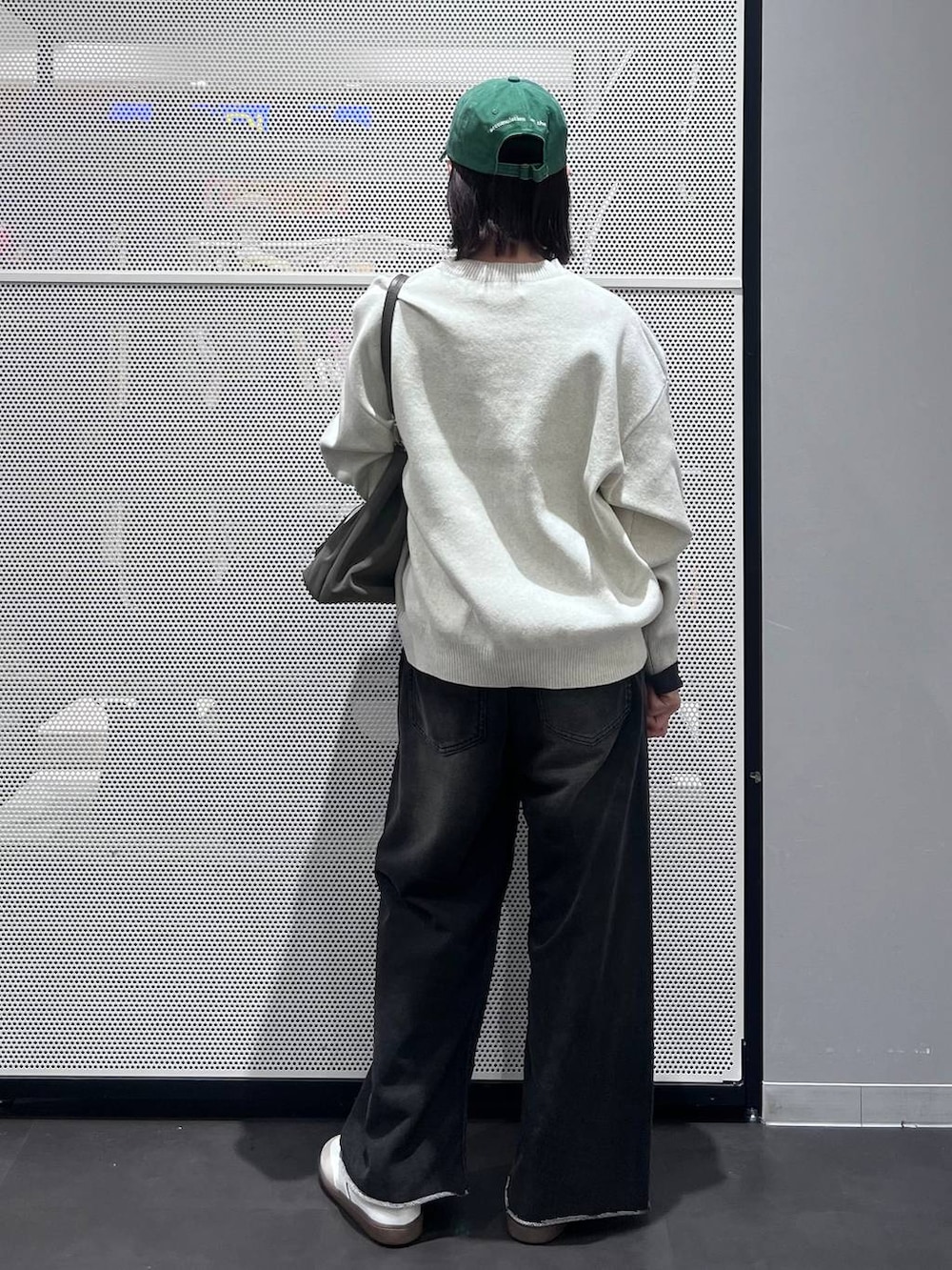 グレー系のTシャツ/カットソー、ホワイト系のスニーカー、イエロー系のニット/セーターを着用したレディースの冬コーディネートの5枚目の写真