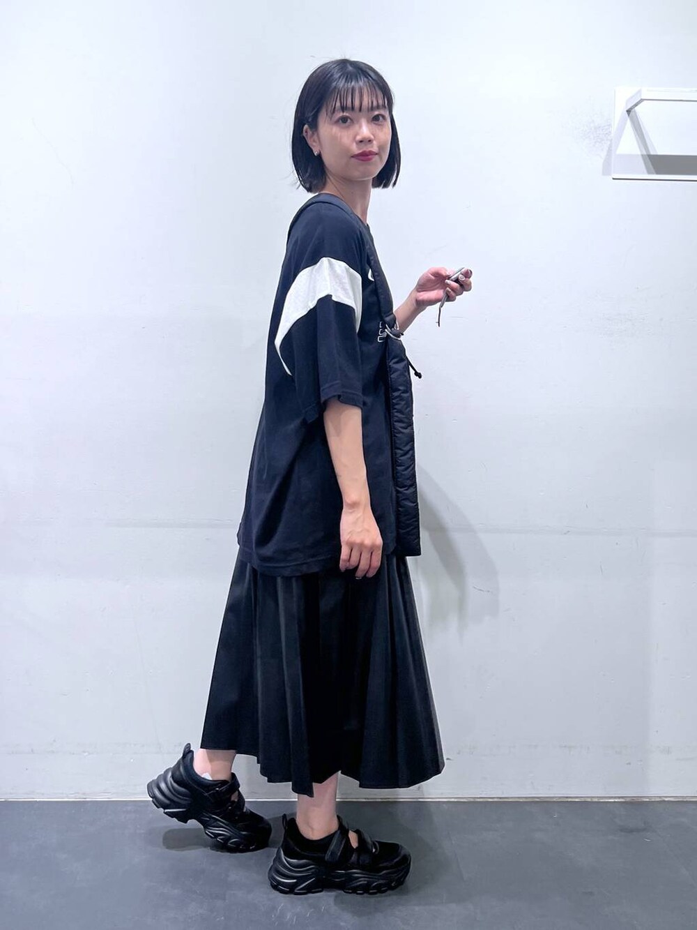 ブラック系のショルダーバッグ、ブラック系のTシャツ/カットソー、ブラック系のスニーカーを着用したレディースの夏コーディネートの4枚目の写真