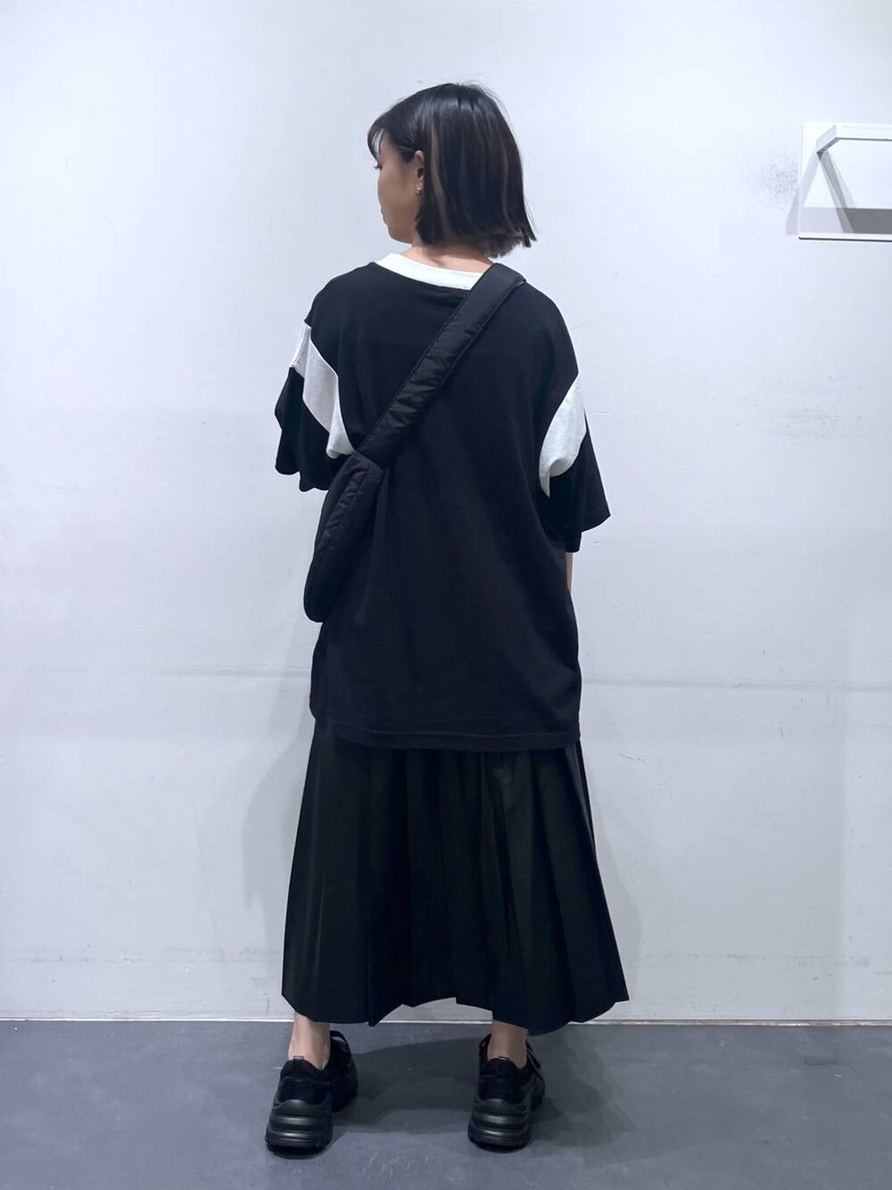 ブラック系のショルダーバッグ、ブラック系のTシャツ/カットソー、ブラック系のスニーカーを着用したレディースの夏コーディネートの5枚目の写真