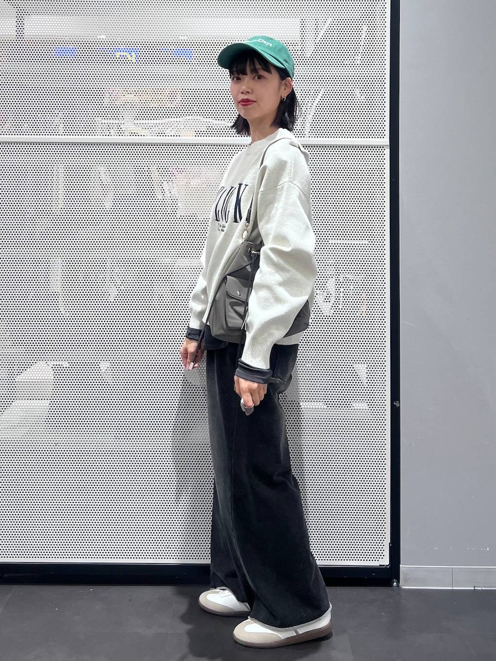 グレー系のTシャツ/カットソー、ホワイト系のスニーカー、イエロー系のニット/セーターを着用したレディースの冬コーディネートの4枚目の写真