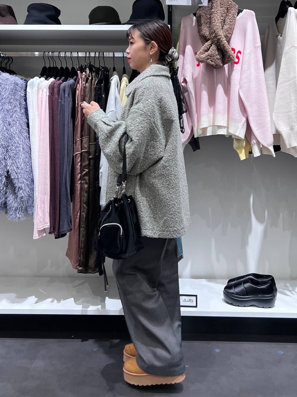 グレー系のブルゾン、イエロー系のスリッポン、ブラック系のショルダーバッグを着用したレディースの秋コーディネートの3枚目の写真