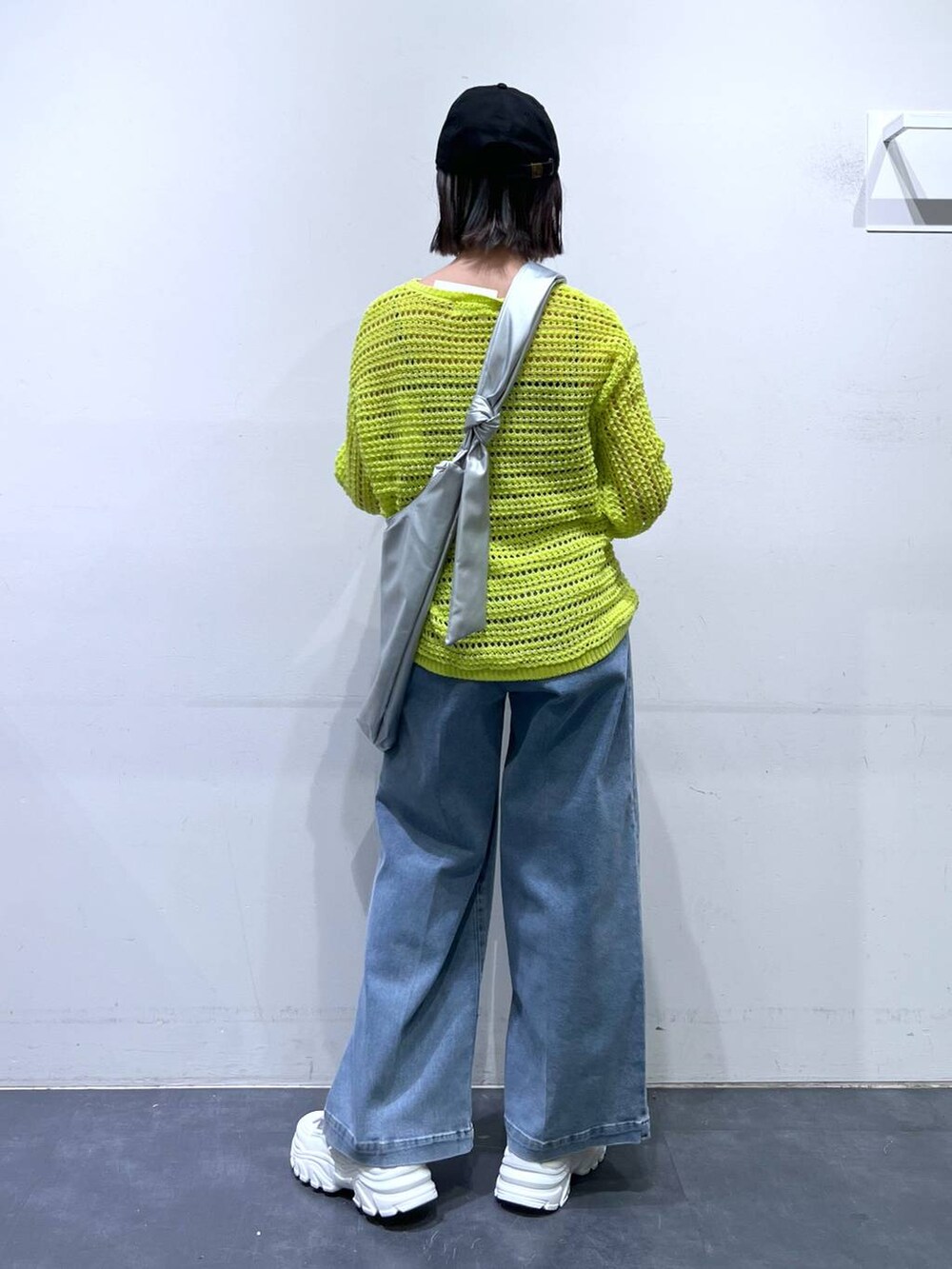 ホワイト系のスニーカー、ブルー系のデニムパンツ、ホワイト系のキャミソールを着用したレディースの春コーディネートの5枚目の写真