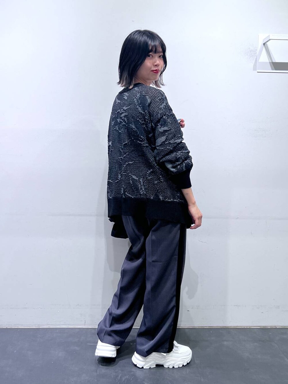 ホワイト系のスニーカー、ブラック系のショルダーバッグ、グレー系のその他パンツを着用したレディースの春コーディネートの4枚目の写真