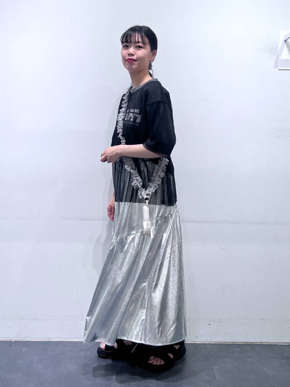 ブラック系のサンダル、シルバー系のスカート、ブラック系のTシャツ/カットソーを着用したレディースの春コーディネートの3枚目の写真